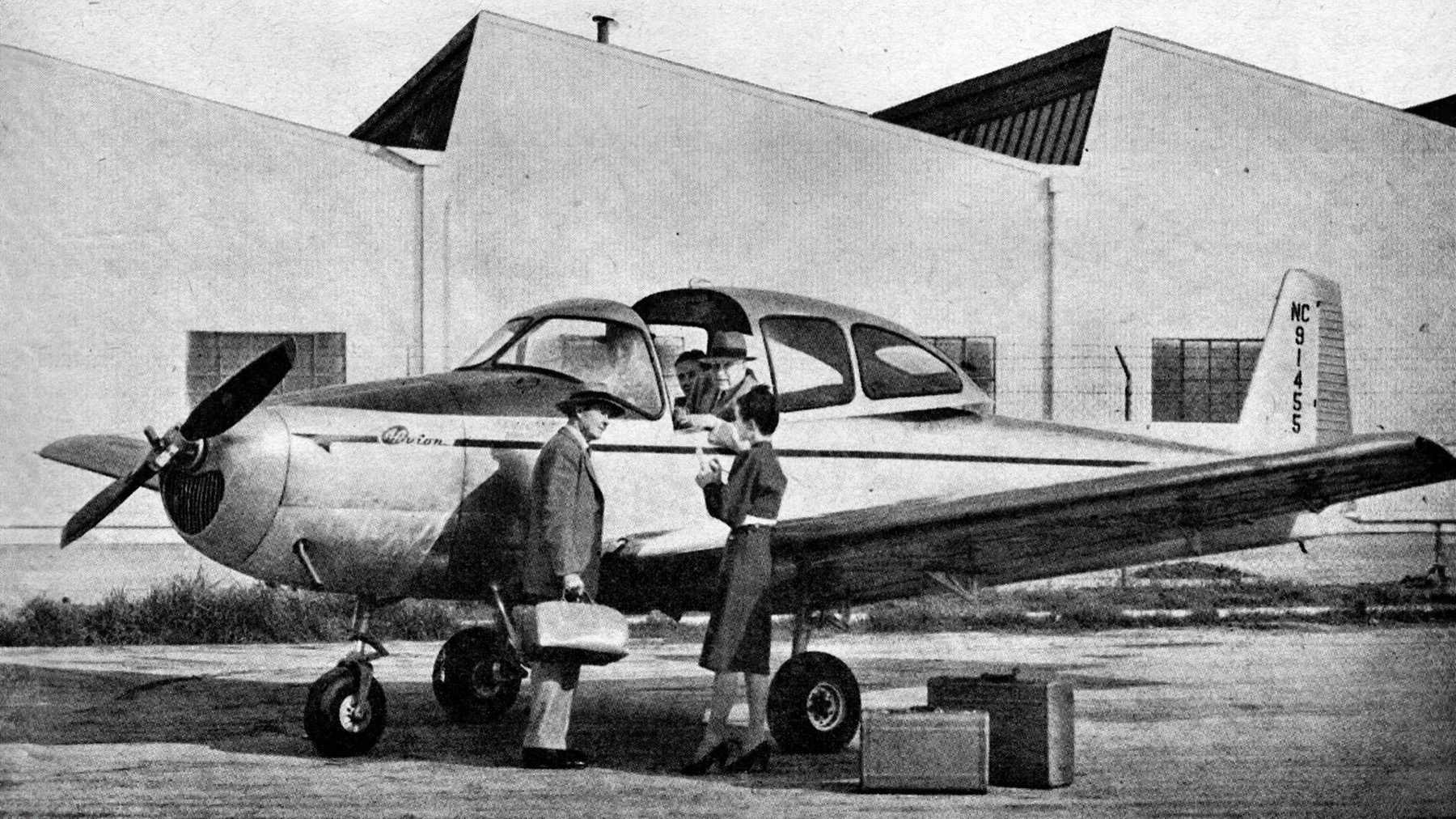 Photo historique du Navion au sol devant un hangar